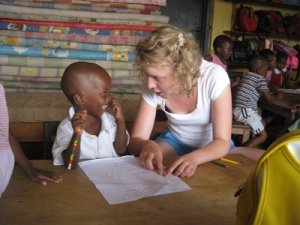 German volunteer plays with child on the Care project in Africa