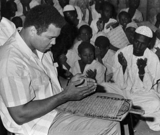 In this 1988 file photo, former world heavyweight boxing champ Muhammad Ali prays with a class of Muslim boys at Dafaalah el Sa'em Mosque in Khartoum, Sudan. As one of the most famous Muslims in the world, he traveled widely as a goodwill ambassador, spreading the message of Islam as a religion of peace. AP/Abder Raouf